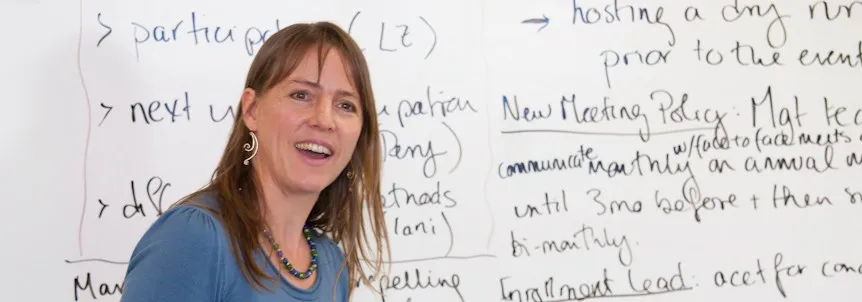 Cecile Green smiling in front of a collaborative whiteboard